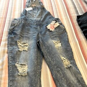 Brand new women’s blue jean overalls with tags attached